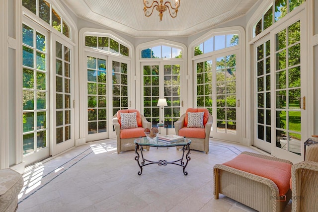 sunroom / solarium featuring a chandelier, wooden ceiling, and a healthy amount of sunlight