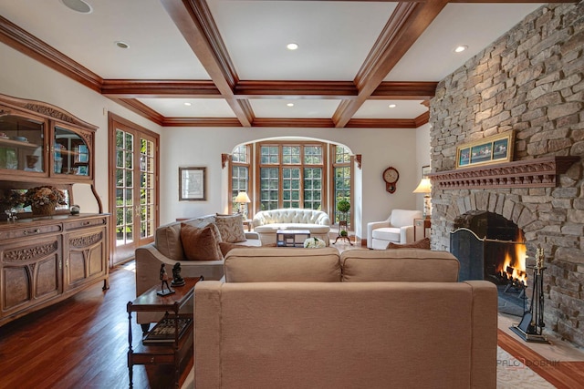 living area featuring coffered ceiling, a fireplace, beamed ceiling, and wood finished floors