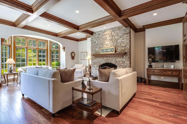 living area featuring coffered ceiling, beamed ceiling, a fireplace, and wood finished floors