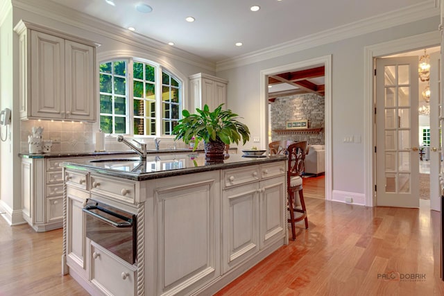 kitchen featuring light wood finished floors, tasteful backsplash, coffered ceiling, beamed ceiling, and a warming drawer