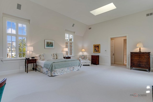 bedroom featuring a skylight, carpet, visible vents, and high vaulted ceiling