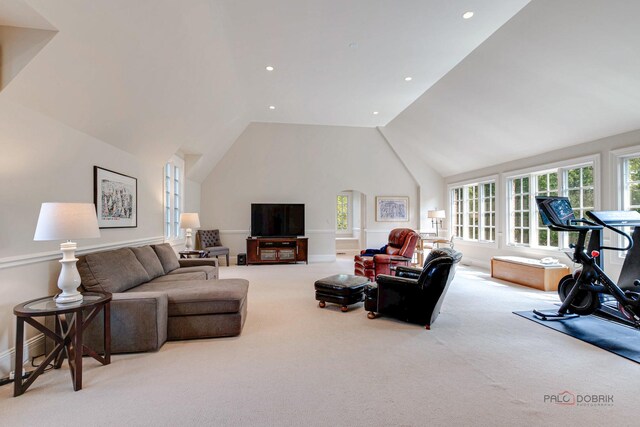 carpeted living room with high vaulted ceiling and recessed lighting