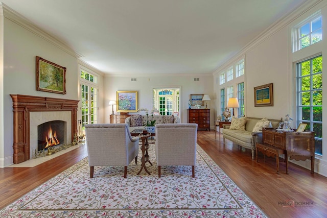 living room featuring visible vents, wood finished floors, a high end fireplace, and crown molding