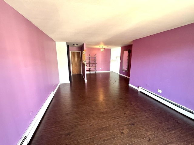 unfurnished living room featuring baseboards, baseboard heating, and wood finished floors