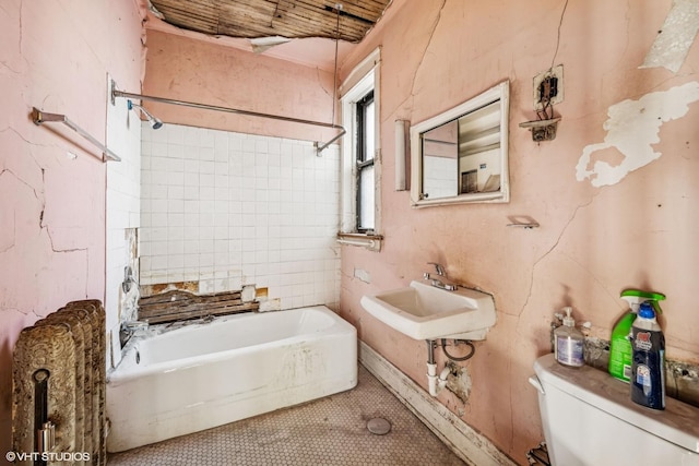 bathroom with bathing tub / shower combination, toilet, and a sink