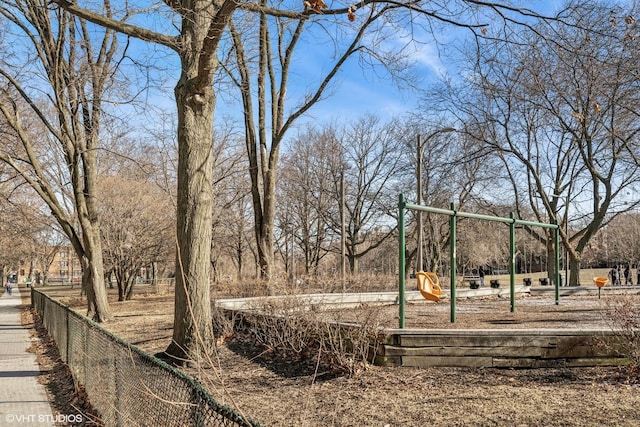 view of property's community featuring playground community and fence