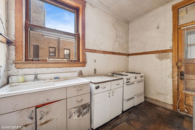 kitchen featuring dark wood finished floors, double oven range, light countertops, white cabinetry, and a sink