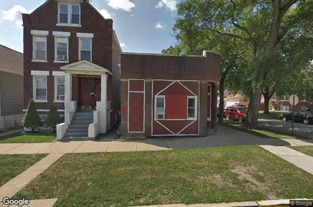 view of front of house with a front lawn and brick siding