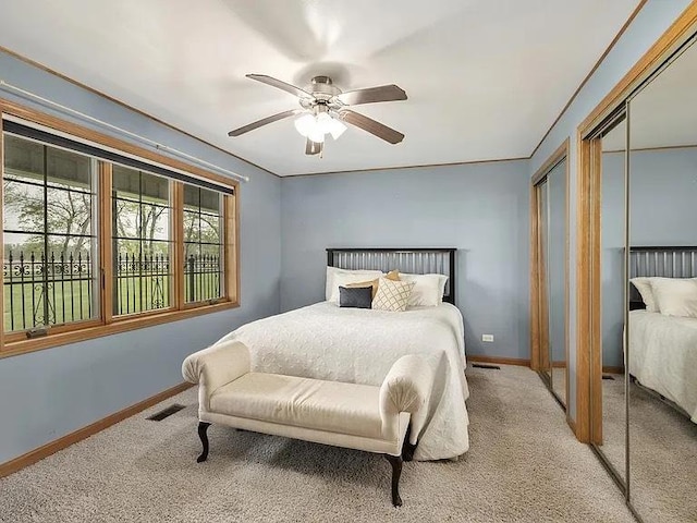 22915 Mcguire Rd, Wilmington, IL 60481 - carpeted bedroom with visible vents, baseboards, two closets, and ceiling fan