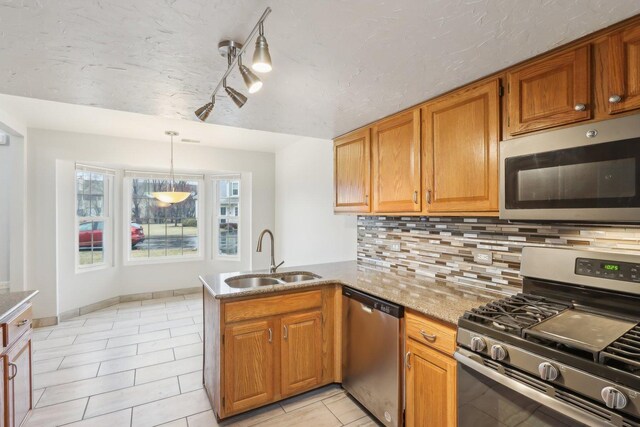 kitchen with tasteful backsplash, appliances with stainless steel finishes, a peninsula, light tile patterned flooring, and a sink