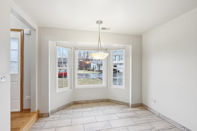 unfurnished dining area with visible vents and baseboards