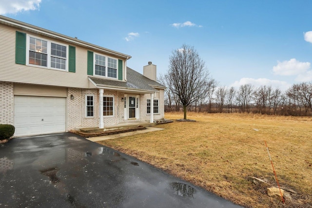 view of front of house with a front lawn, aphalt driveway, a garage, brick siding, and a chimney