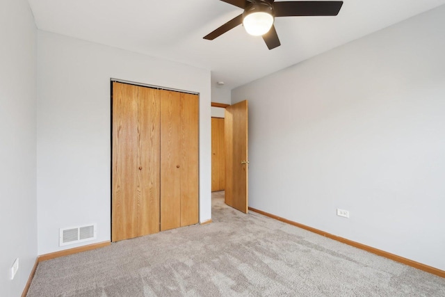 unfurnished bedroom featuring visible vents, ceiling fan, baseboards, carpet, and a closet