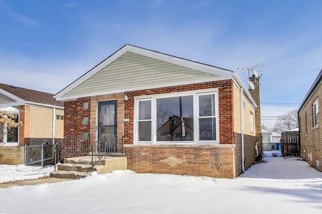 view of front of house featuring brick siding, fence, and a gate