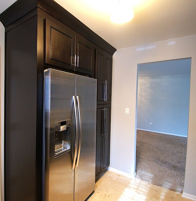 kitchen featuring dark brown cabinetry, baseboards, and stainless steel fridge with ice dispenser