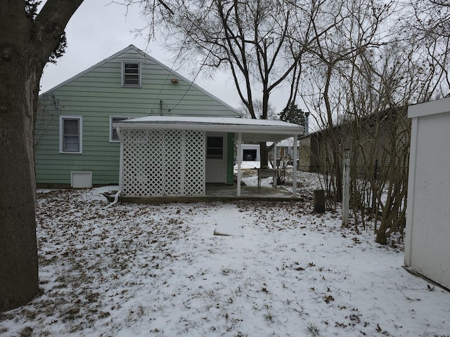 snow covered property featuring a carport