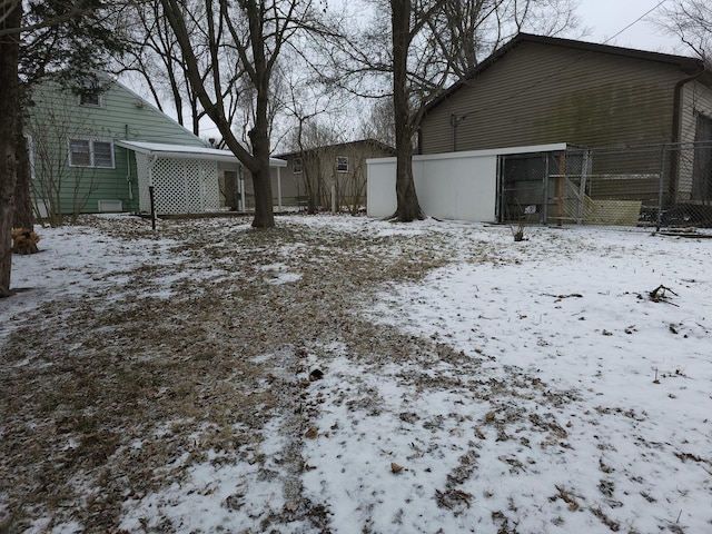 snowy yard featuring fence