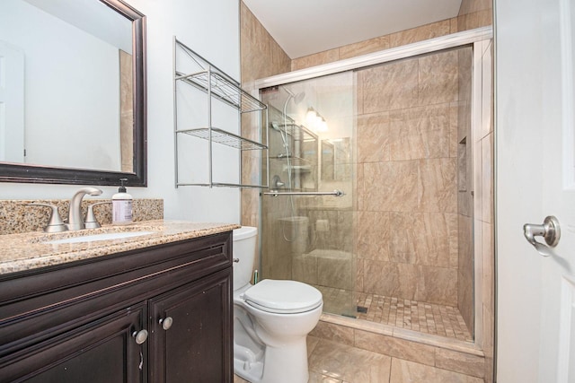 full bathroom featuring toilet, a stall shower, and vanity