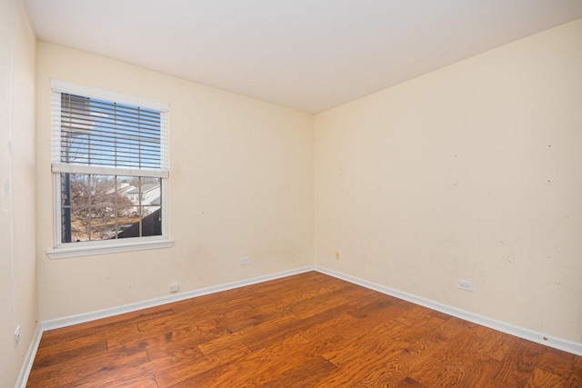 spare room with wood finished floors and baseboards