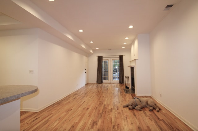 unfurnished living room with a fireplace, recessed lighting, visible vents, light wood-type flooring, and baseboards