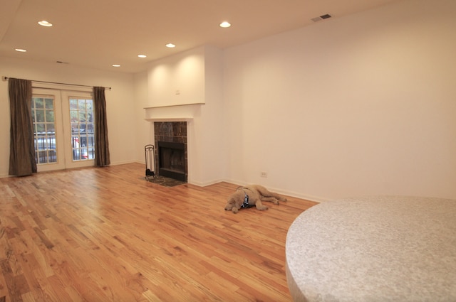 unfurnished living room with recessed lighting, a fireplace, visible vents, baseboards, and light wood-type flooring