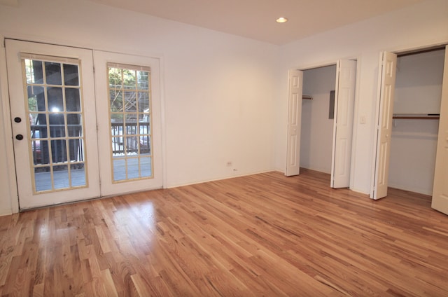 unfurnished bedroom with multiple closets, access to outside, light wood finished floors, and recessed lighting