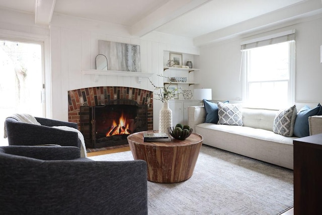 living area with beam ceiling and a fireplace