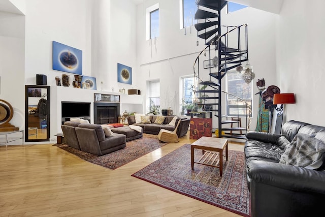 living room featuring stairs, a fireplace, and wood finished floors