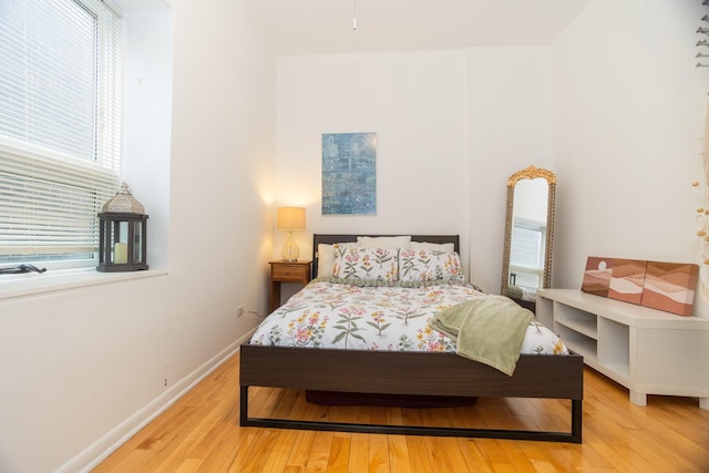 bedroom with baseboards and light wood finished floors