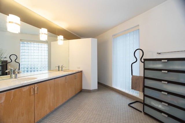 bathroom featuring lofted ceiling, double vanity, a sink, and baseboards