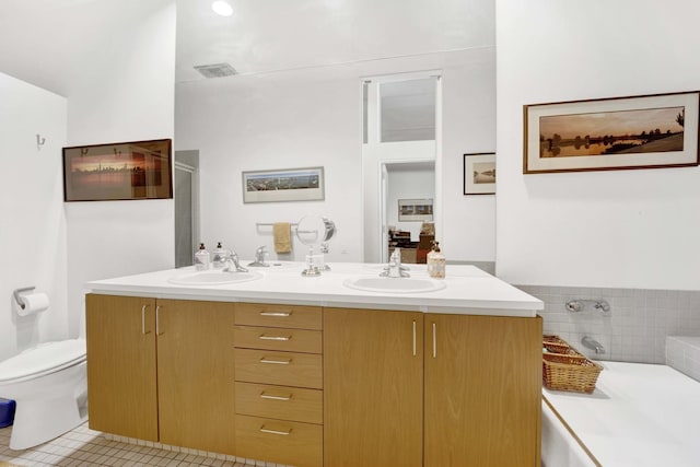 full bath with a garden tub, double vanity, a sink, and visible vents