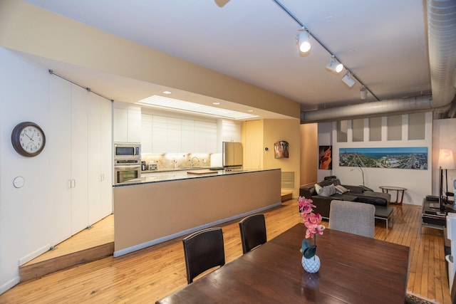 dining room featuring light wood-type flooring and rail lighting