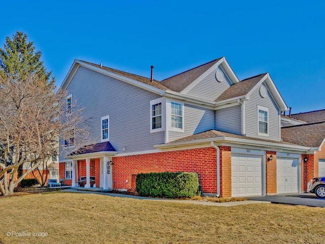 view of front of property with driveway, a front lawn, central AC, a garage, and brick siding