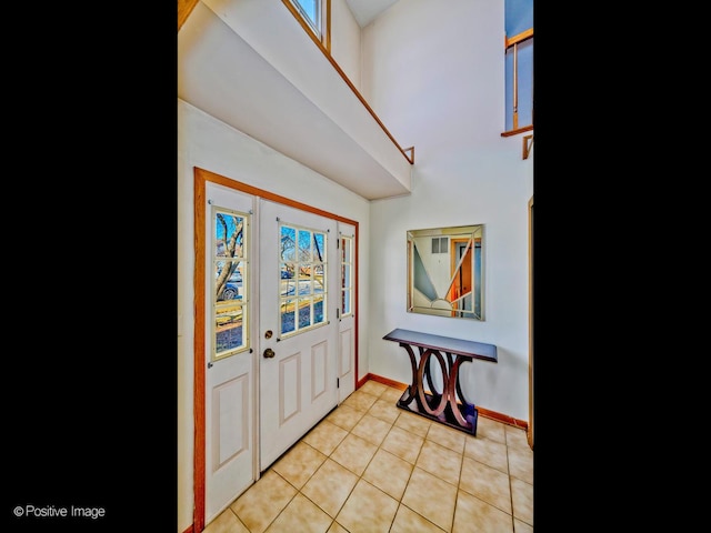 foyer featuring light tile patterned floors and baseboards