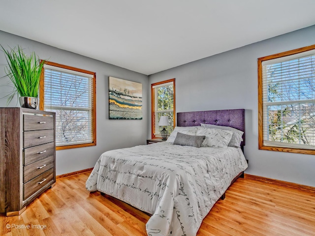 bedroom with light wood finished floors and baseboards