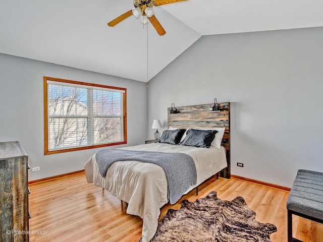 bedroom featuring a ceiling fan, lofted ceiling, wood finished floors, and baseboards