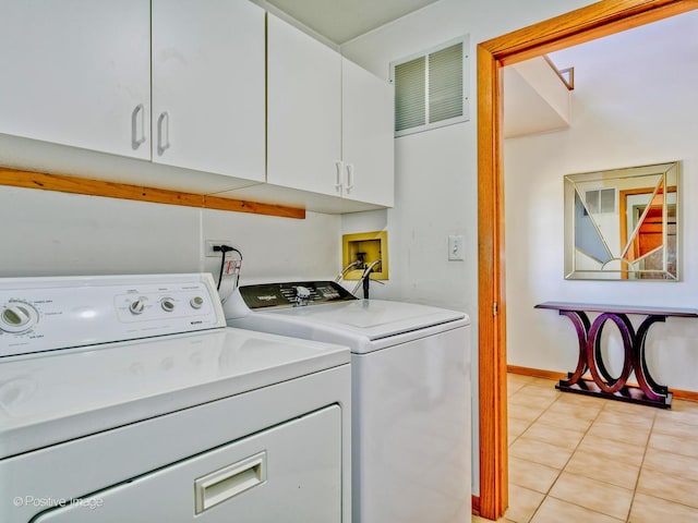 laundry area featuring light tile patterned floors, visible vents, cabinet space, and washing machine and dryer