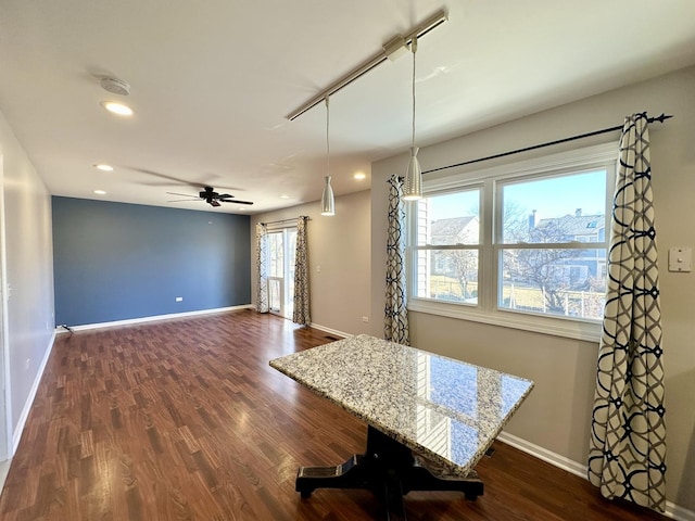 unfurnished dining area featuring plenty of natural light, baseboards, and dark wood-style flooring