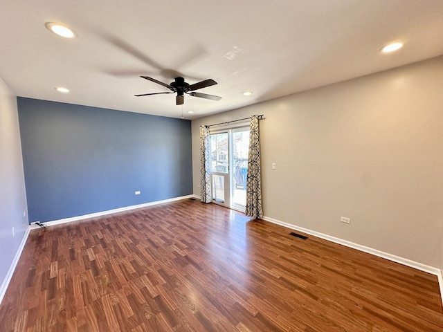 empty room with dark wood-type flooring, recessed lighting, visible vents, and baseboards