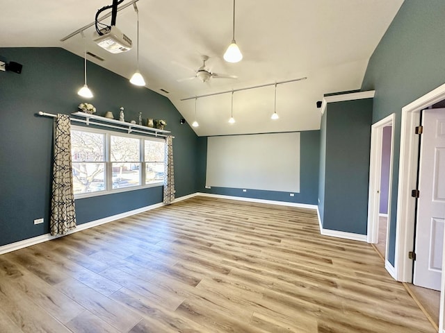 spare room featuring lofted ceiling, ceiling fan, track lighting, and wood finished floors