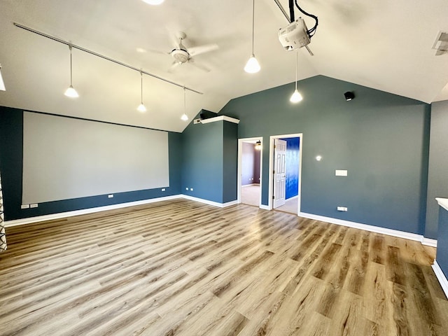 interior space featuring vaulted ceiling, wood finished floors, a ceiling fan, and baseboards