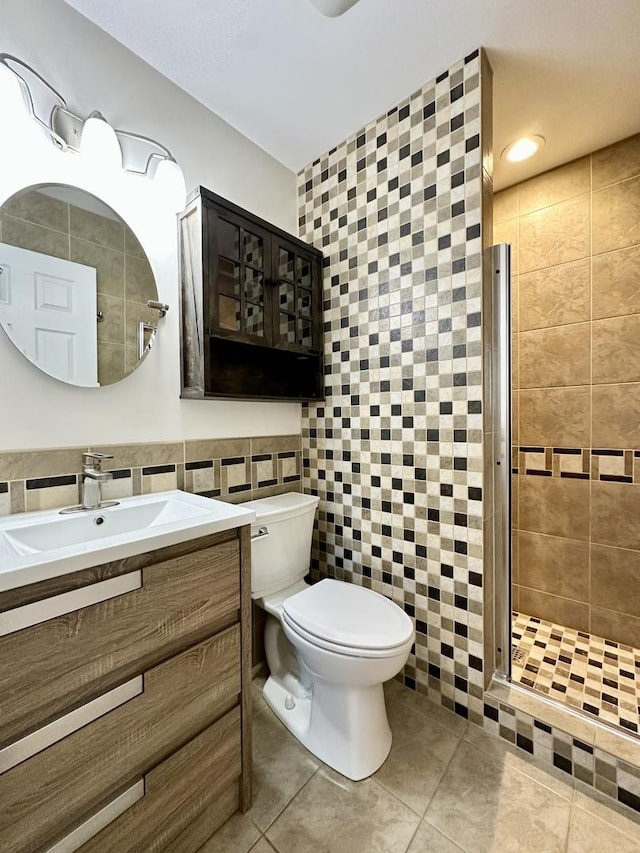 full bathroom with toilet, tile patterned flooring, vanity, a shower stall, and tile walls