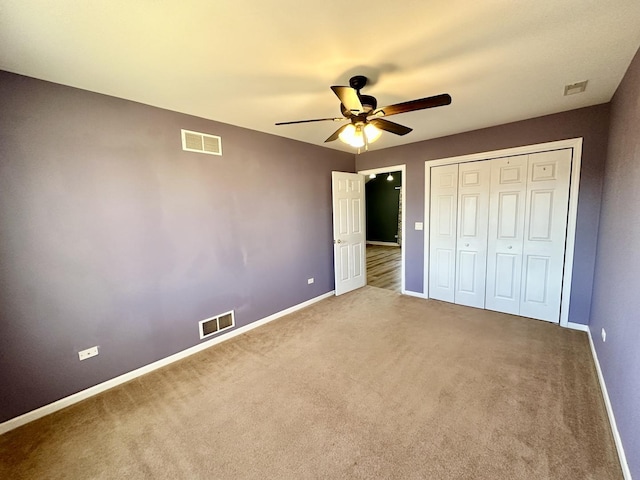 unfurnished bedroom featuring carpet floors, baseboards, visible vents, and a closet