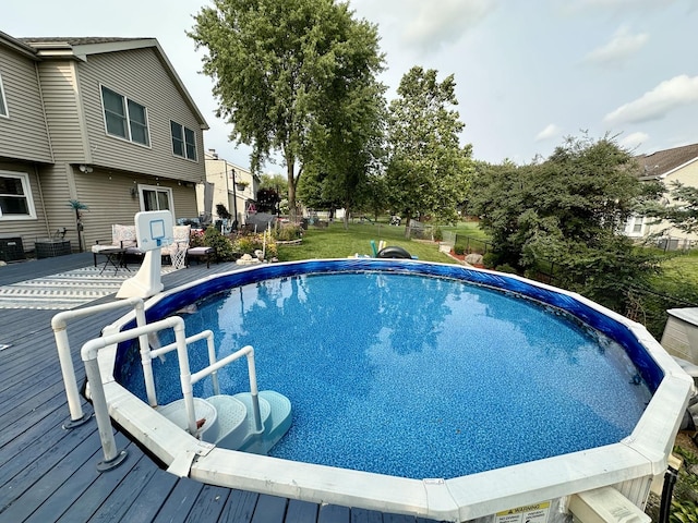 outdoor pool featuring a wooden deck and fence