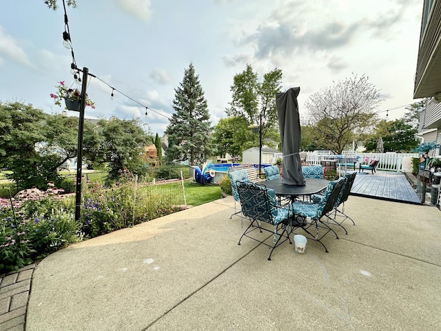 view of patio / terrace featuring outdoor dining space, fence, and a deck