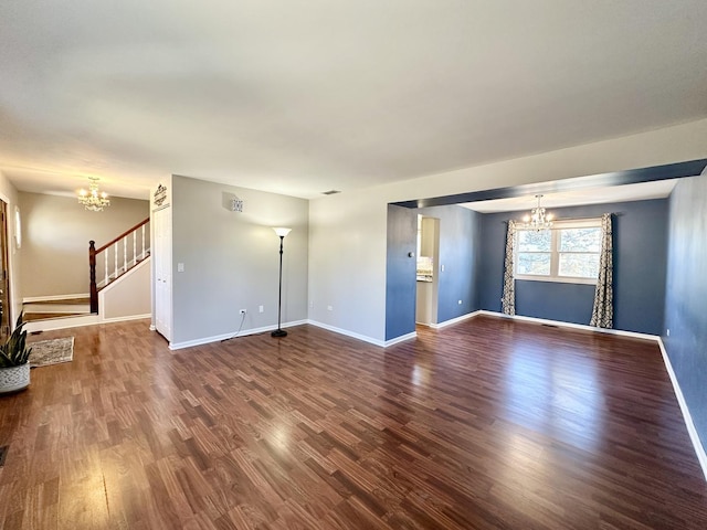 unfurnished living room with stairs, baseboards, a notable chandelier, and wood finished floors