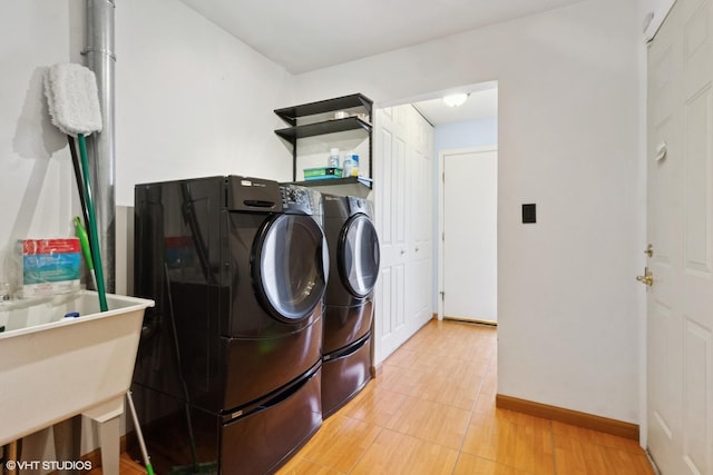 washroom featuring baseboards and separate washer and dryer