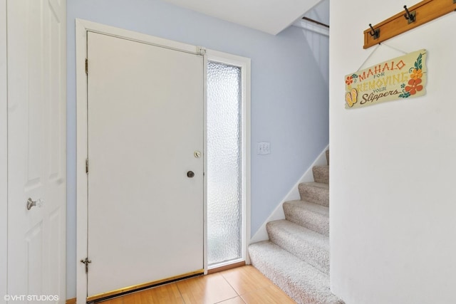 foyer entrance with light wood-type flooring and stairway