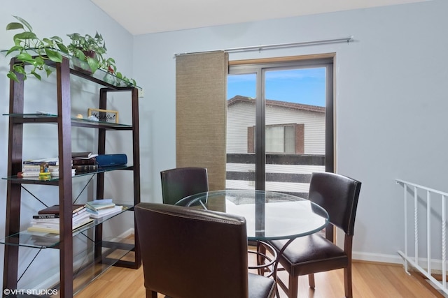 dining space with baseboards and wood finished floors