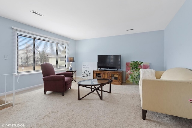 carpeted living area featuring visible vents and baseboards